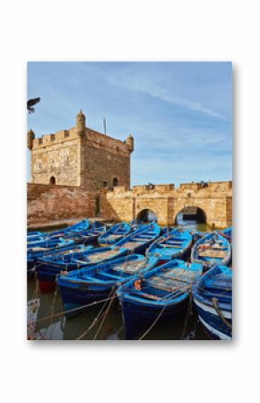 Fort of Essaouira in Morocco on a sunny day with blue boats on the water