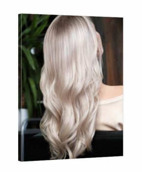 Young woman in a hairdressing salon dyes her hair blond