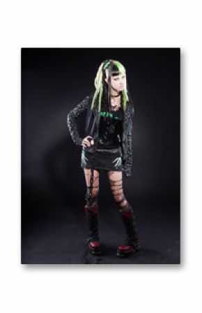 Cyber punk girl with green hair and red eyes against black wall.