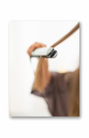 Closeup on young woman using hair straightener