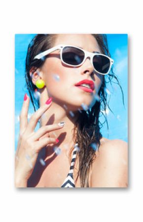 Young attractive woman wearing sunglasses by the swimming pool