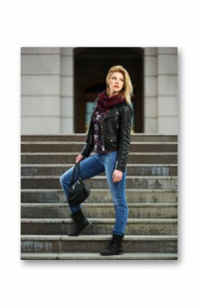 Young fashion blond woman in leather jacket on the steps