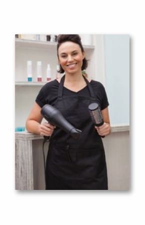 Smiling hairdresser holding hair equipment