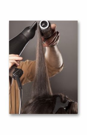 hairdresser doing his client hair with a hair drier and comb