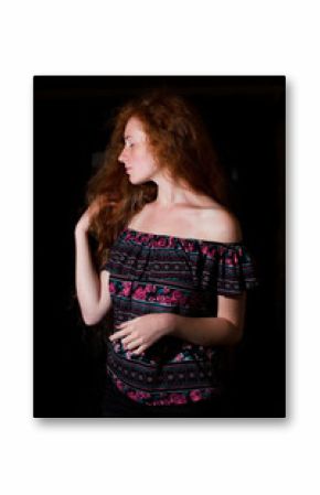 Beautiful red haired model with lush curly hair and naked shoulders