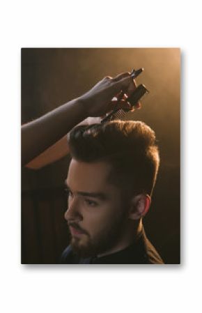 Stylish young male in hairdressing salon. Unrecognizable hairdresser cutting modern man hair, handsome guy portrait in focus on foreground, beauty concept