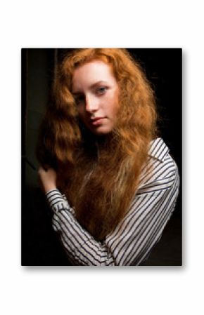 Closeup portrait of young red haired model with long lush hair. Woman posing in a old flat