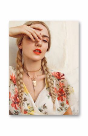 Close-up portrait of a beautiful young woman with a gorgeous bindi on her forehead. Long blonde hair is tangled in wonderful hairstyle. And she is dressed in a pretty dress.
