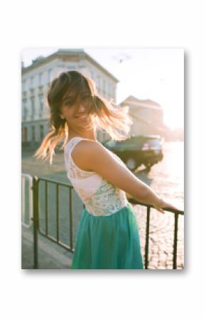 Tender blonde woman with charming smile posing at the sunrise and sun glare