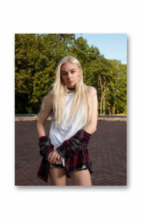 Luxurious young model with long hair wearing casual clothes and posing in the park
