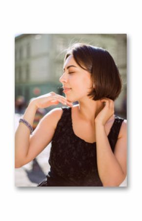 Lifestyle portrait of smiling woman wearing trendy dress walking on the city streets