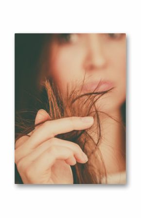 Worried woman looking at her dry hair ends