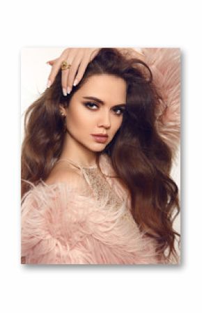 Fashion studio portrait of beautiful girl in fur coat. Brunette with long healthy hair, makeup and manicure nails in luxurious clothes posing at camera.