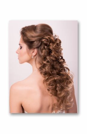 Wedding hairstyle on the head of a brown-haired woman in the back view on a white background close-up.