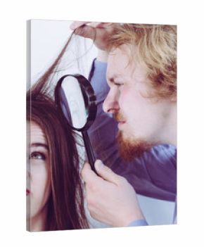 Man looking at woman hair through magnifer