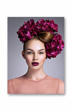 Young woman with a bouquet of purple flowers in her hair.