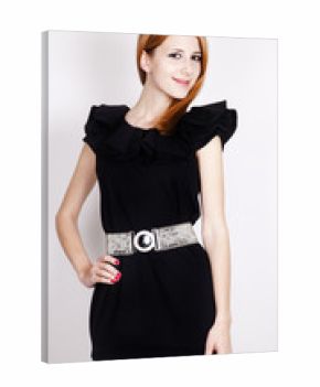Young red-haired lady in black dress posing