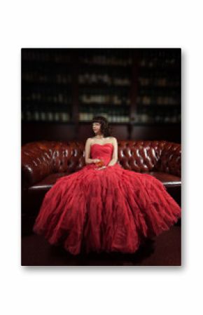 Woman in red evening dress sitting on the sofa