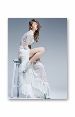 beautiful woman in long white dress posing fashion in the studio