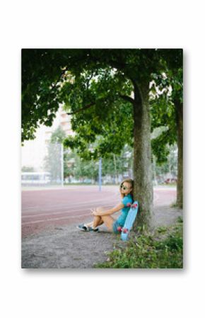 beautiful girl sitting near the skateboard