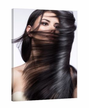 Beautiful brunette girl in move with a perfectly smooth hair, and classic make-up. Beauty face. 