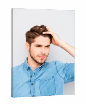Handsome man touching his hair isolated on gray background