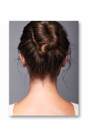 Head and shoulders of a young woman from the back side. Female hair knotted