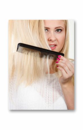 Blonde woman brushing her long hair with comb