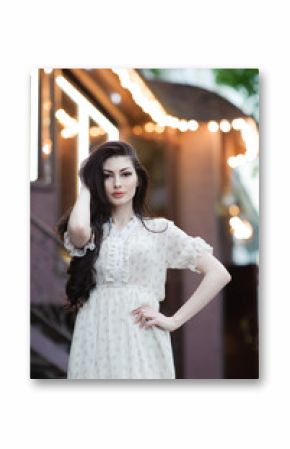 beautiful caucasian girl touching her long hair in summer dress on background urban cafe location