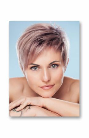 Portrait of a beautiful blonde woman with beautiful make-up and short haircut after dyeing hair in a hairdressing salon on a pink background.