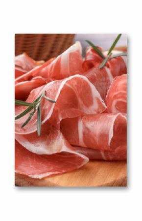 Slices of tasty cured ham and rosemary on wooden board, closeup