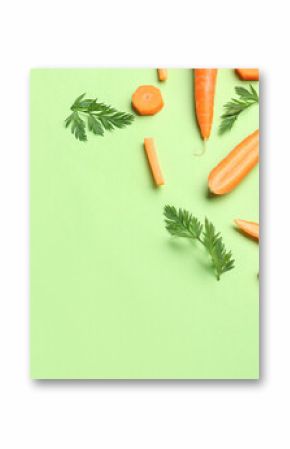 Fresh carrots and slices on green background