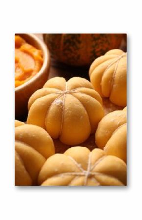 Raw pumpkin shaped buns and ingredients on table, closeup