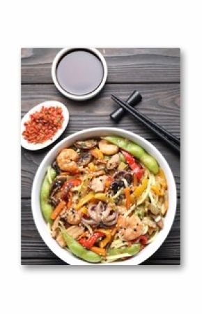 Stir-fry noodles with sea food served on wooden table, flat lay