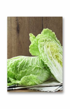 Whole and cut Chinese cabbages on wooden table