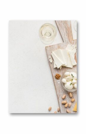 Set of cheese with nuts on wooden board and wine glasses over white concrete background, top view, copy space. Cheese and wine concept