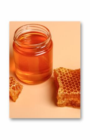 Jar with sweet honey and combs on orange background