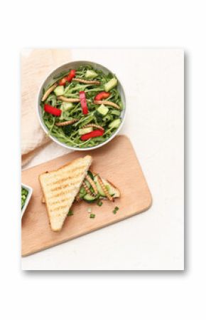 Sandwich with fried maggots and bowl of fresh salad on white background
