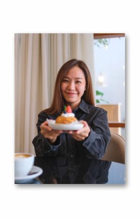Portrait image of a woman holding and serving a plate of strawberry choux cream