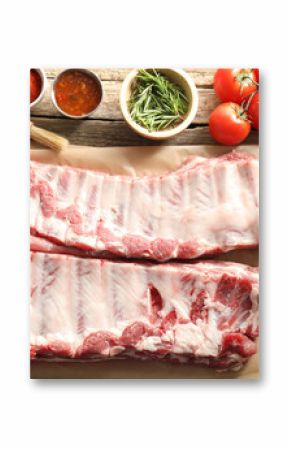 Raw pork ribs, spices and tomatoes on wooden table, flat lay