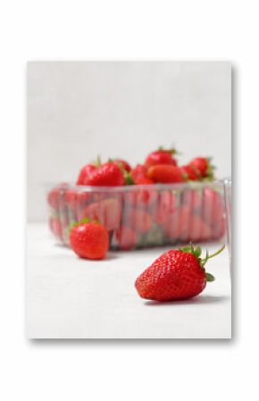 Plastic containers with fresh strawberry on light background, closeup