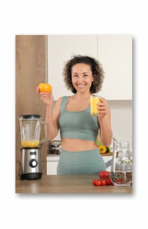 Sporty mature woman with healthy smoothie and tomato in kitchen