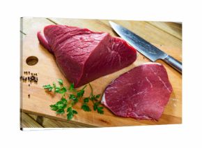 On cutting kitchen table there are fresh raw beef veal meat tenderloin. Raw beef tenderloin and spices, set of products for cooking baked and fried steak. Spices black pepper and herbs