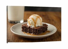 Delicious chocolate brownies paired with creamy ice cream and drizzled caramel on a rustic wooden surface, close-up