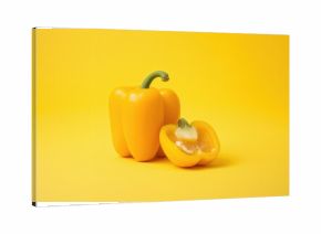 Entire yellow bell pepper with a sliced half, set against a plain backdrop