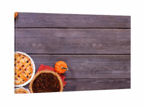 Homemade autumn pie corner border. Top down view on a dark wood banner background with copy space. Variety of apple, pumpkin and pecan pies.