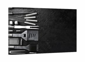 Steel barbecue and grill set. On a black slate table. Top view.