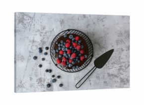 Sweet chocolate cake with fresh berries on grey background