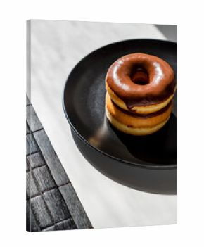 Stack of Two Mini Chocolate Glazed Donuts on a Black Plate