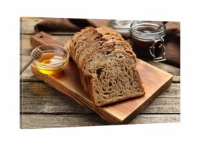 Bread slices with honey and jam on wooden table